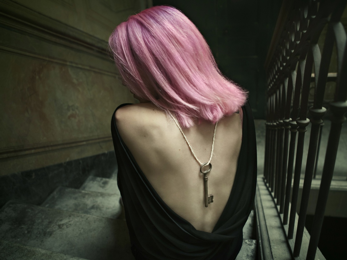 Девушка с розовыми волосами сидит на лестнице