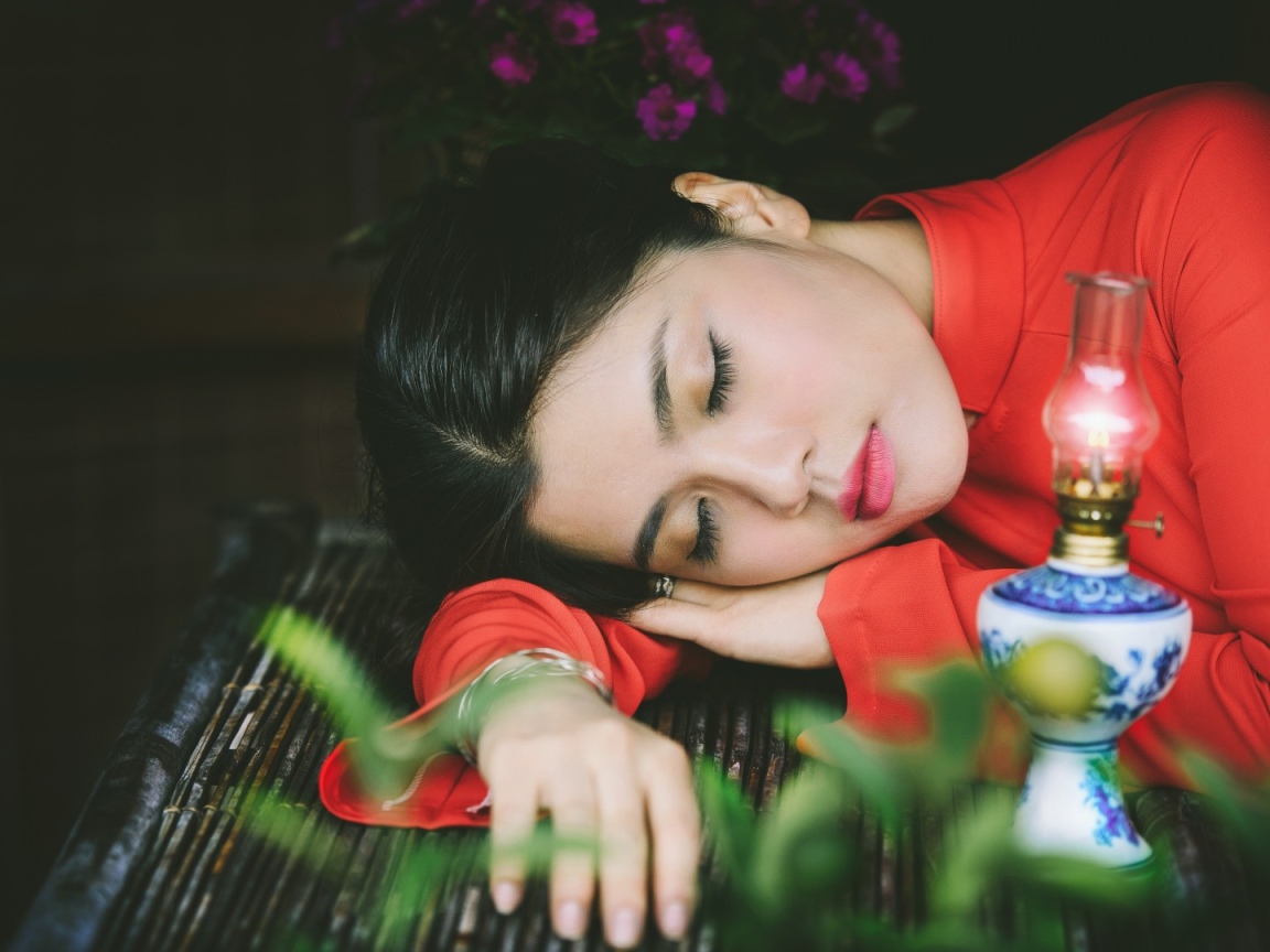 Азиатка спит положив голову на руки