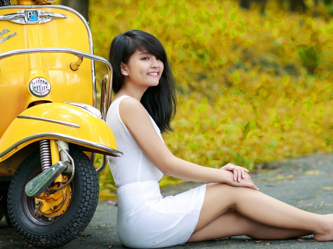 Азиатская девушка у желтого мотороллера