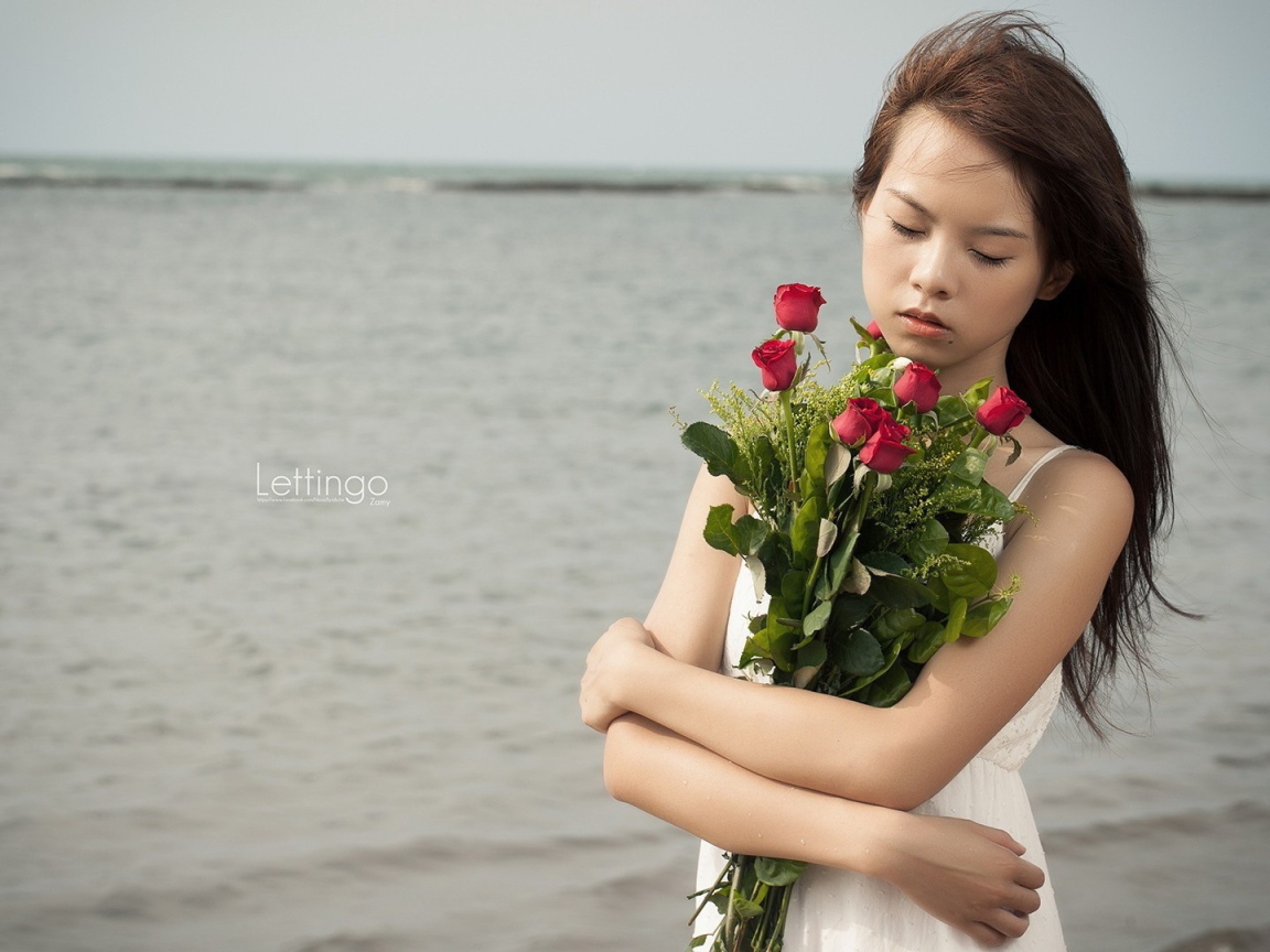 Азиатка держит в руках букет роз
