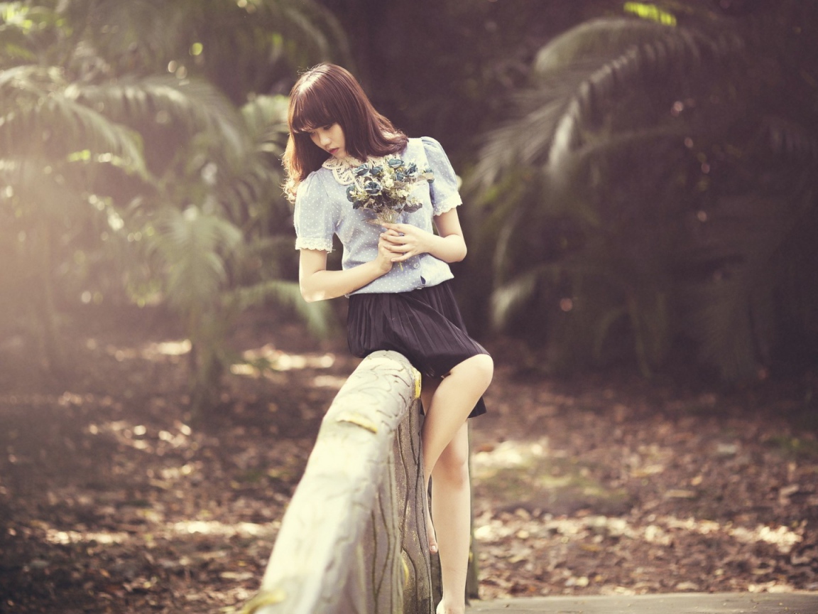 Азиатка с букетом на поручне моста