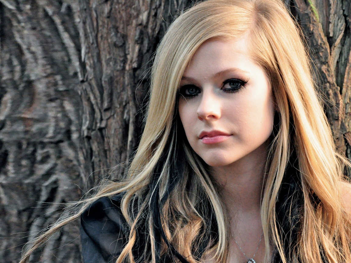 Блондинка Аврил Лавин на фоне коры дерева