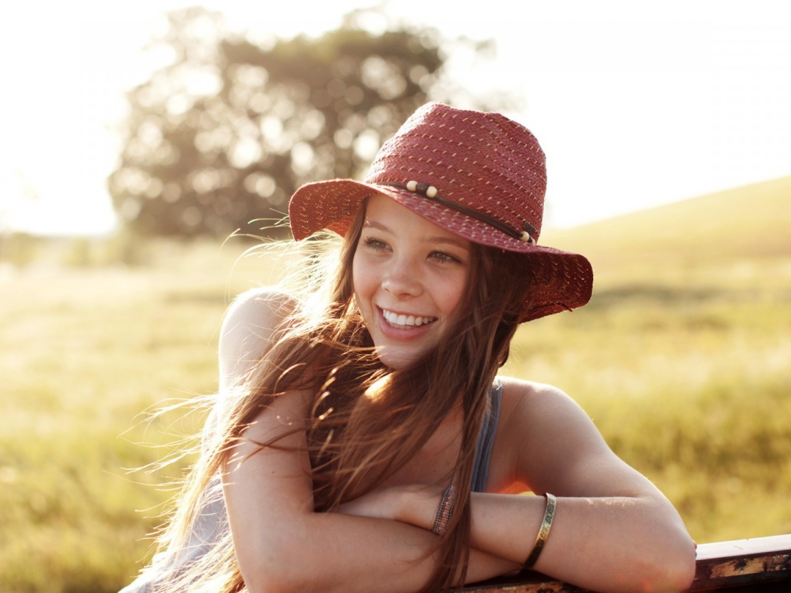 Веселая девушка в легкой красной шляпе