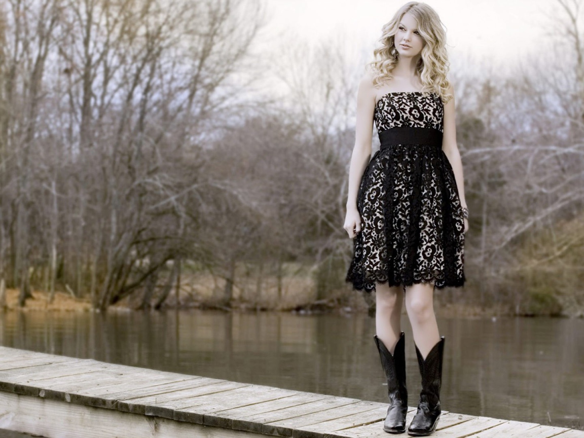 Девушка в черном платье и кожаных сапогах