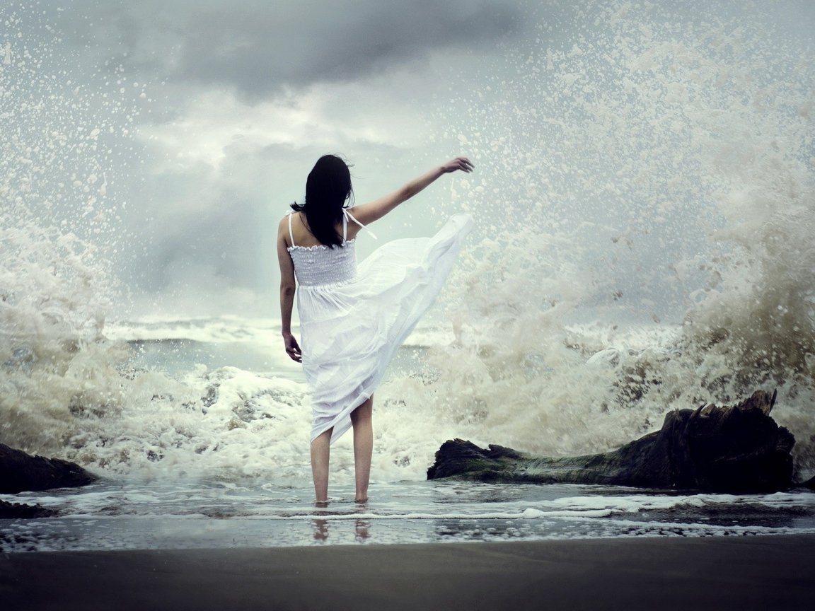 Девушка в белом платье среди брызг прибоя