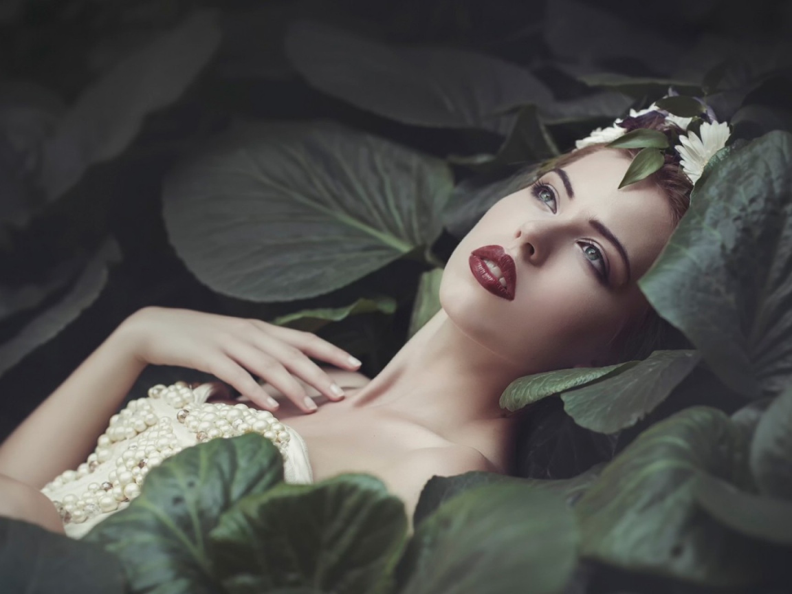 Девушка лежит в больших листьях