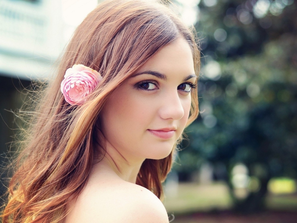 Девушка модель с розовым цветком в волосах