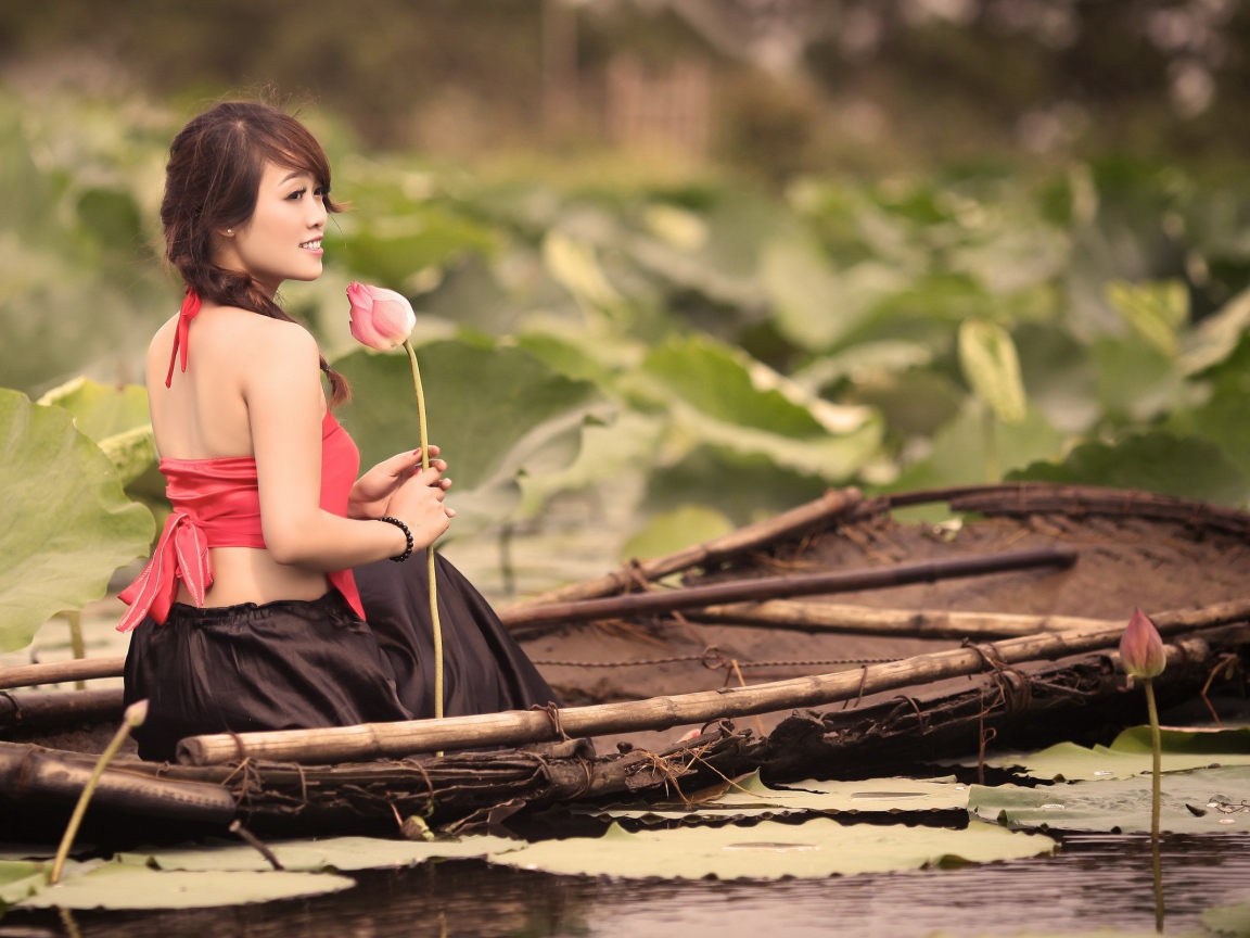 Girl with flower sitting in a boat