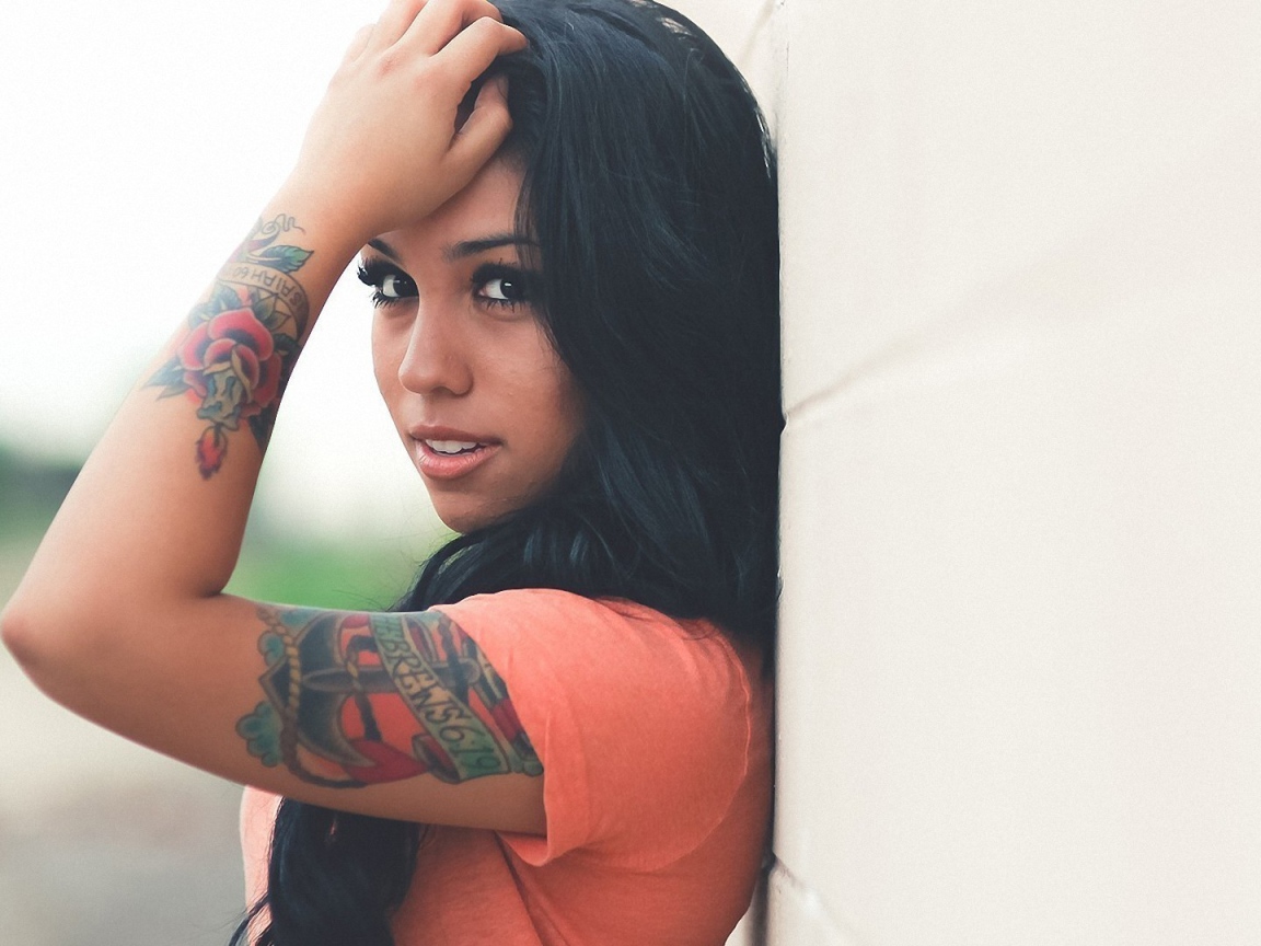 Страстная длинноволосая брюнетка прислонилась к стене