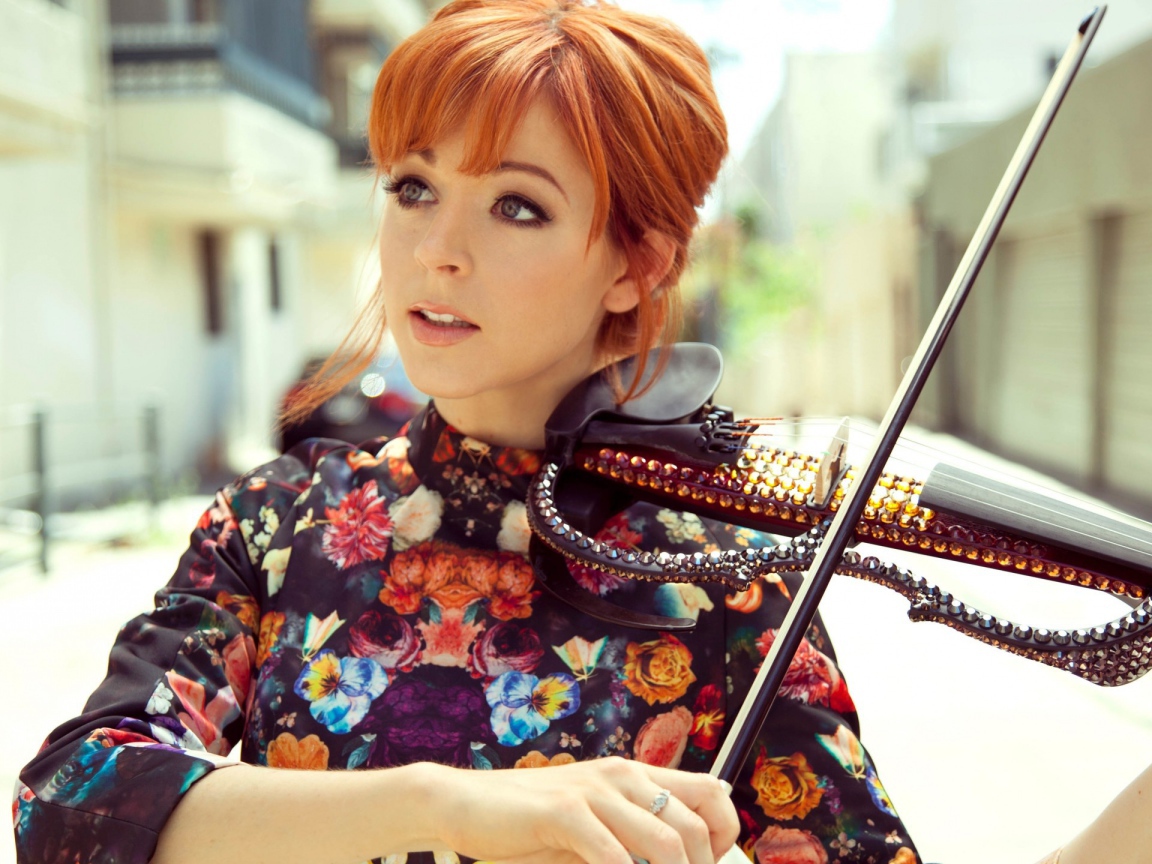 Рыжая девушка играет на скрипке со стразами