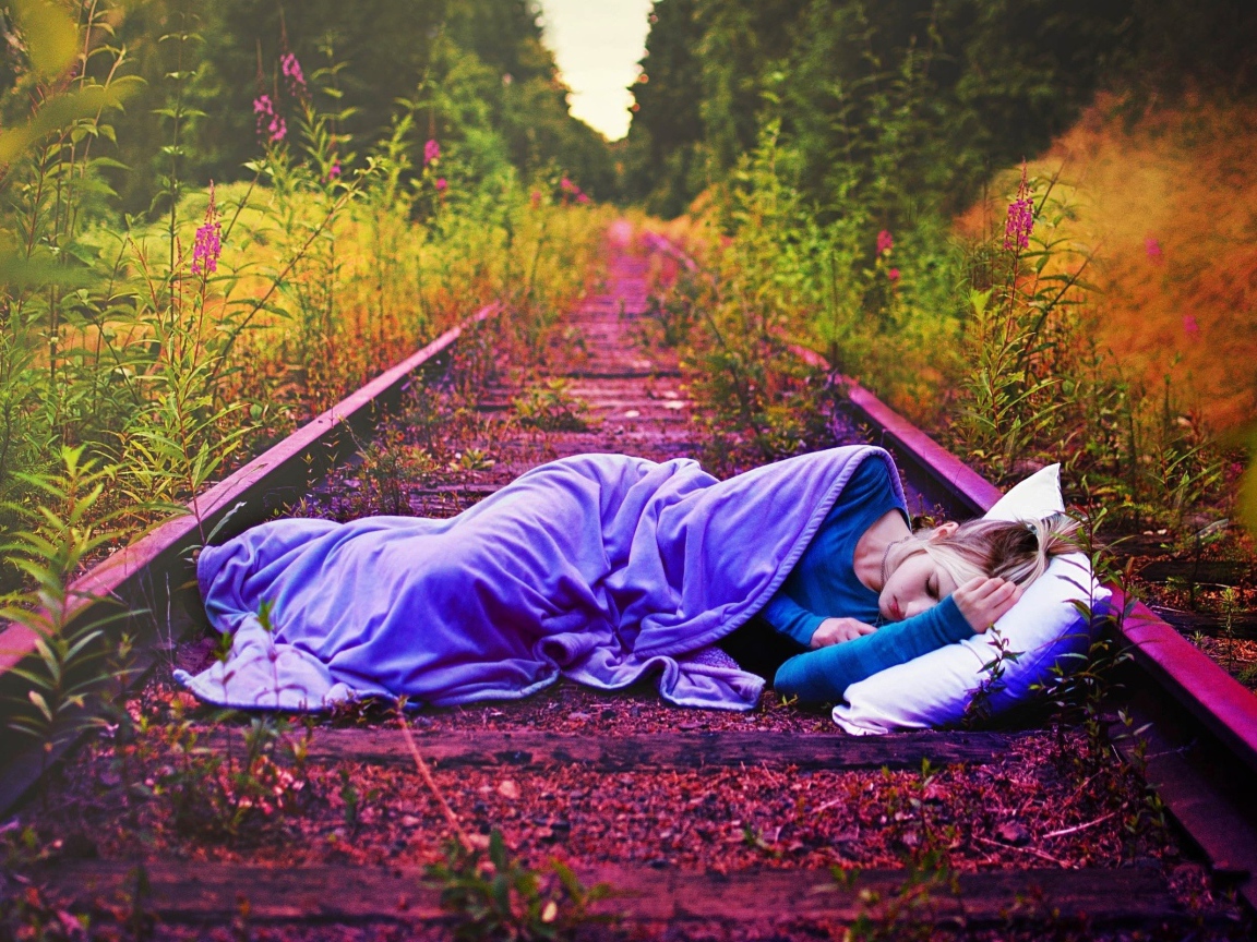 Девушка спит на заброшенных рельсах