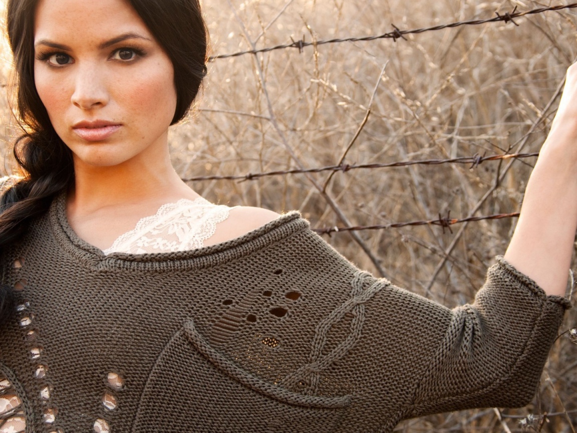 Девушка у забора из колючей проволоки