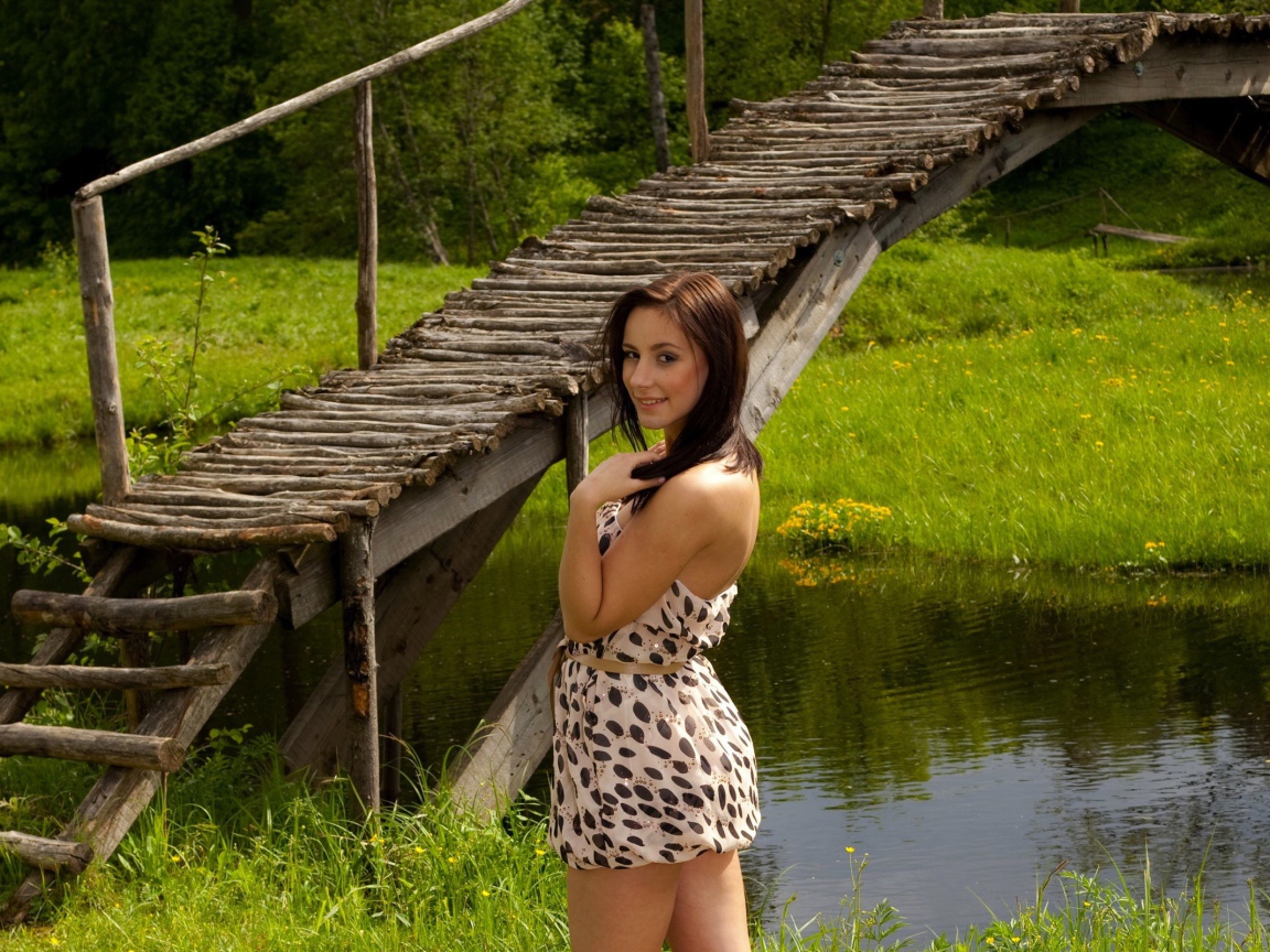 Девушка у деревянного моста через реку