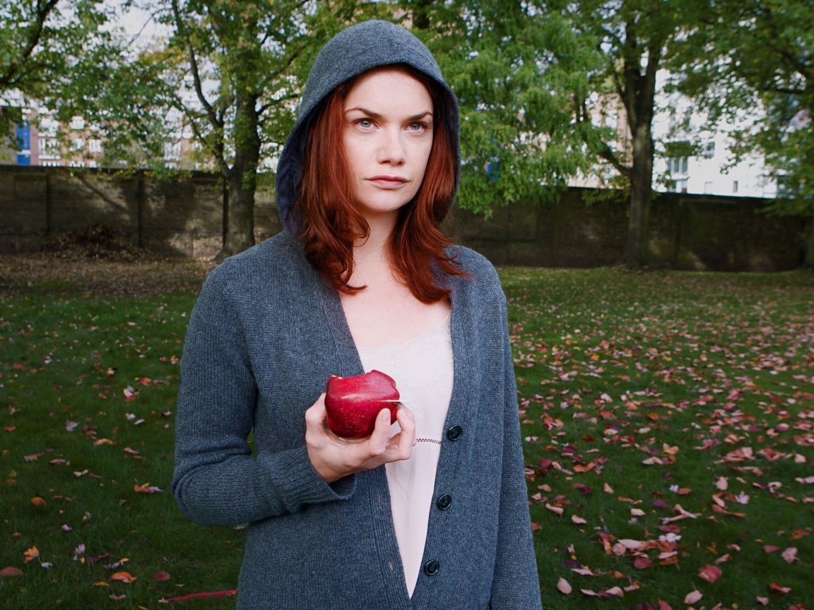 Девушка в капюшоне с яблоком