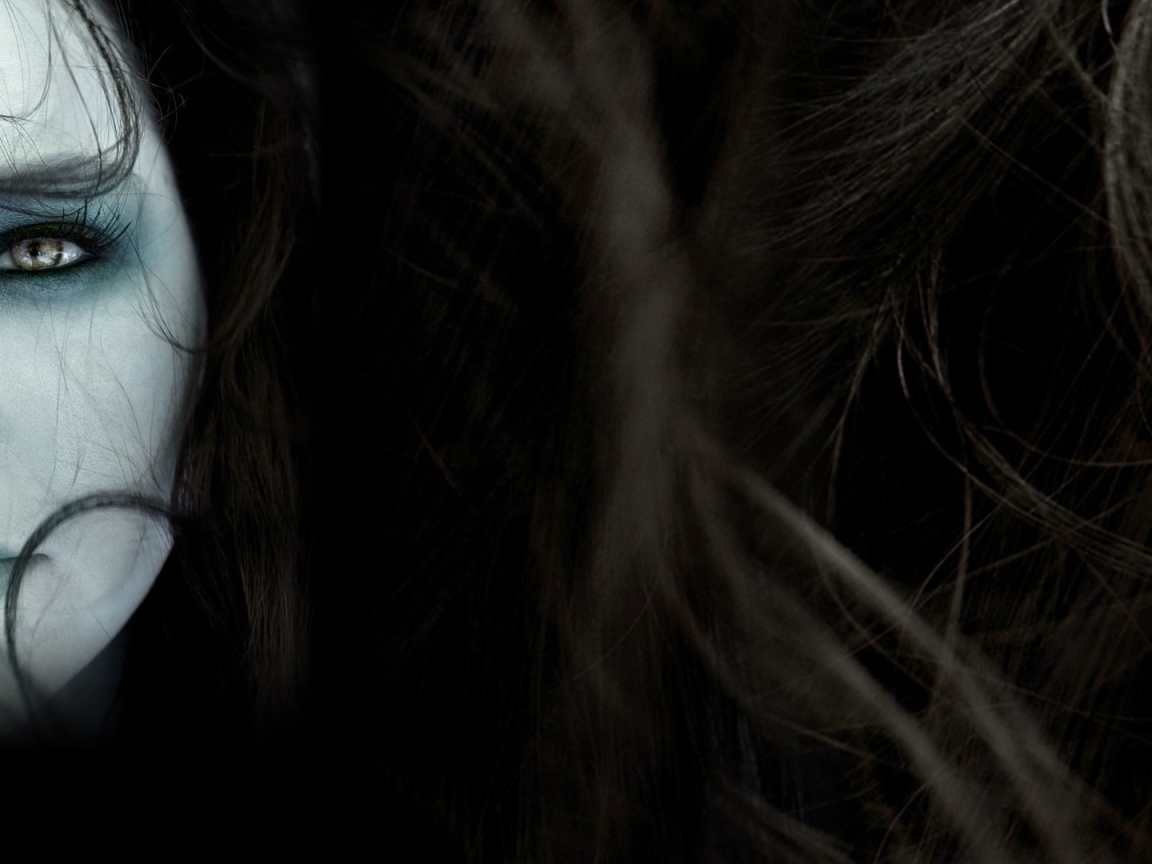 Лицо девушки среди волос на темном фоне