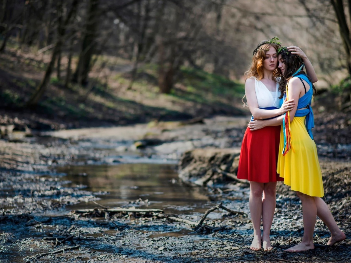 Две девушки в ярких платьях в чаще леса