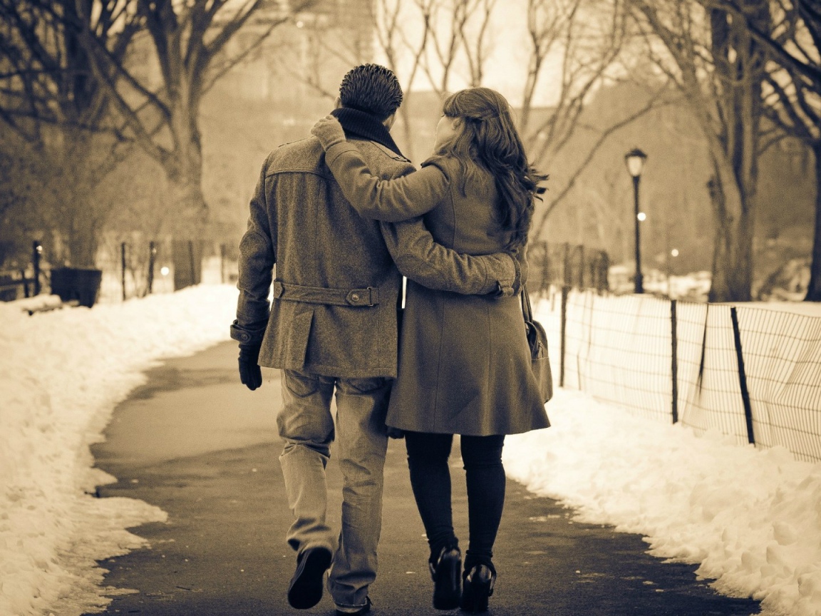 Влюбленные гуляют по зимнему парку