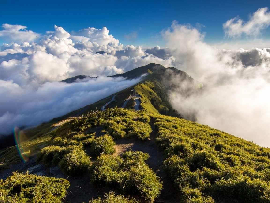 Зеленый горный хребет среди облаков