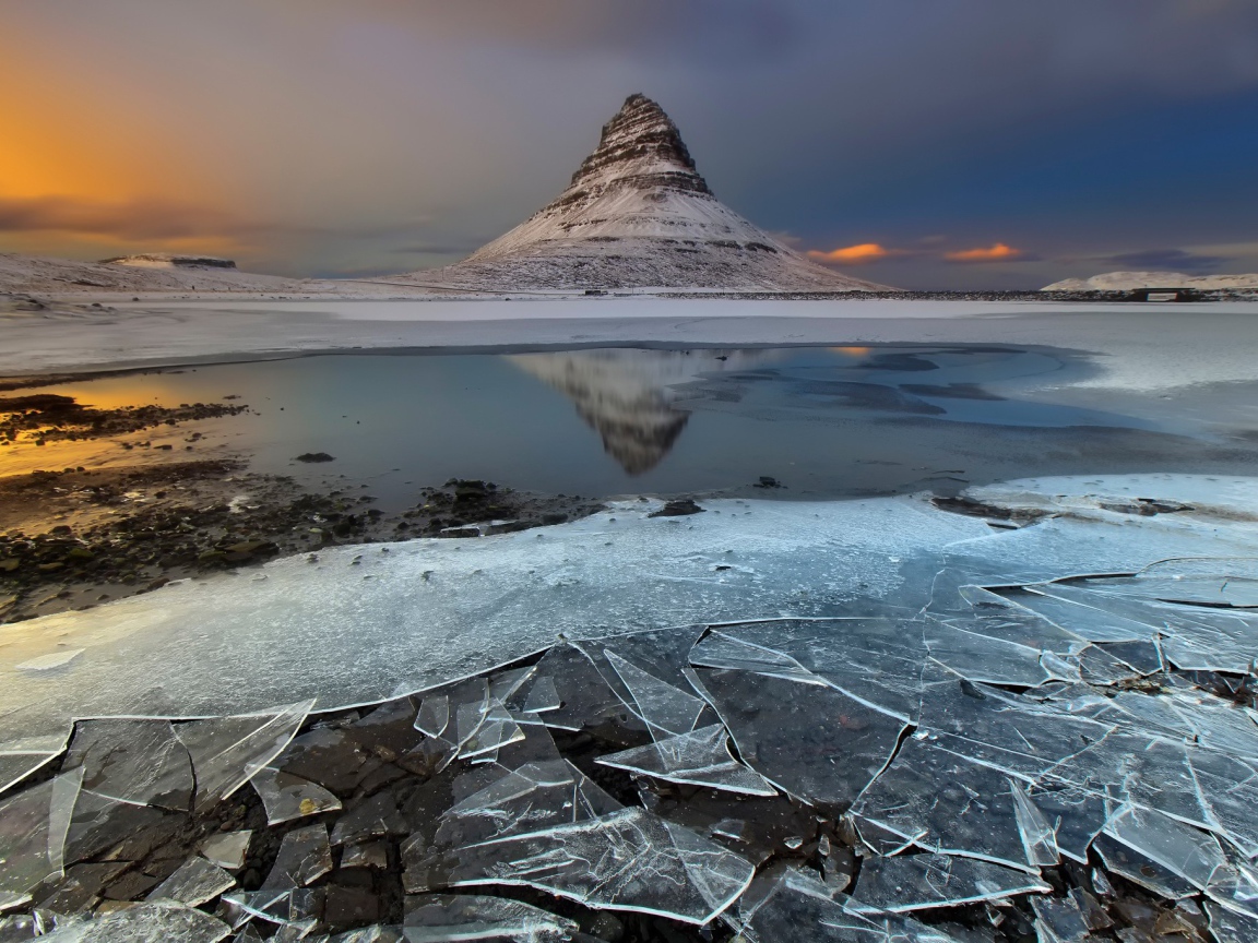 Тонкий лед озера на фоне горы