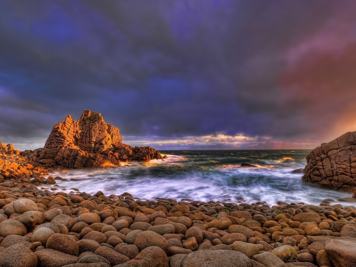 Большие гладкие камни на берегу бурного моря