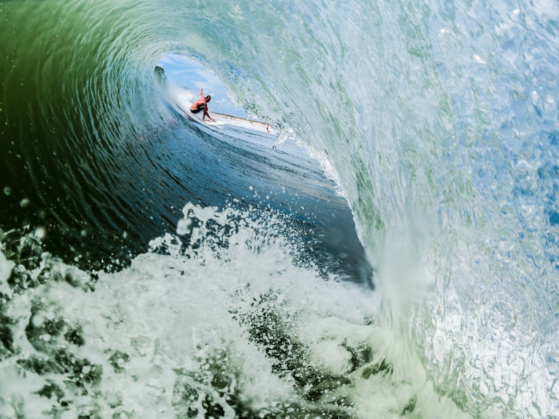 Серфер внутри пенистой волны