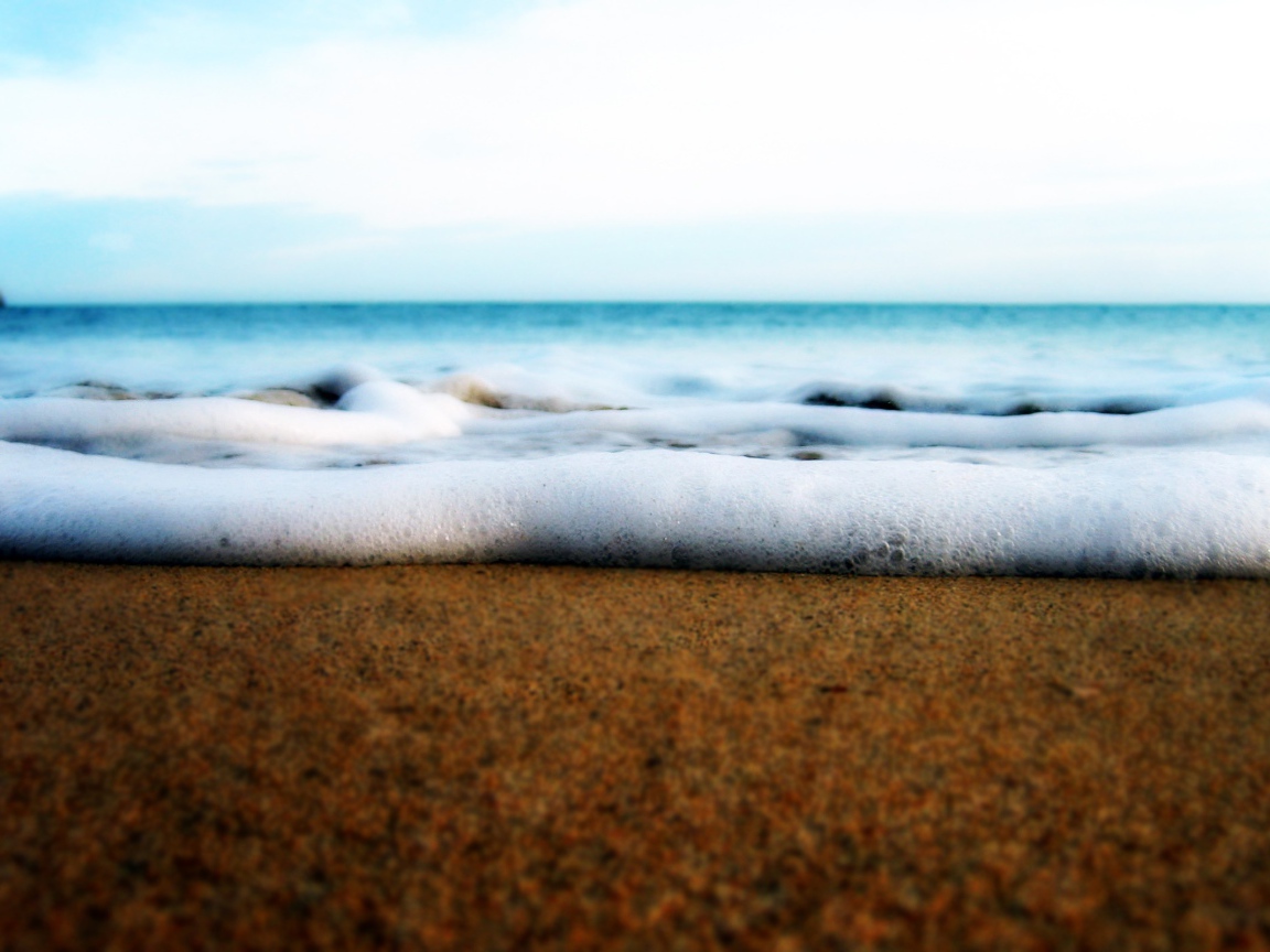 Белая пена волны у берега