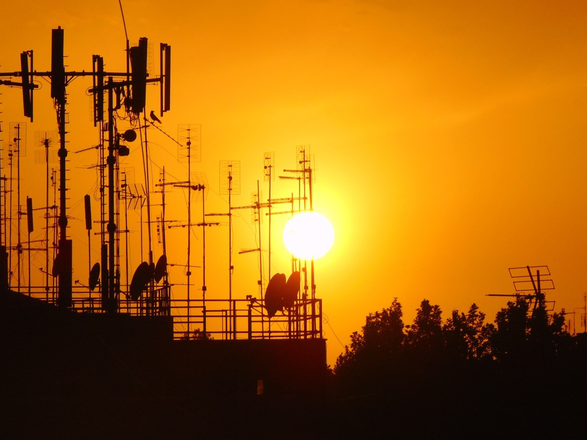 Вышки связи на фоне солнца