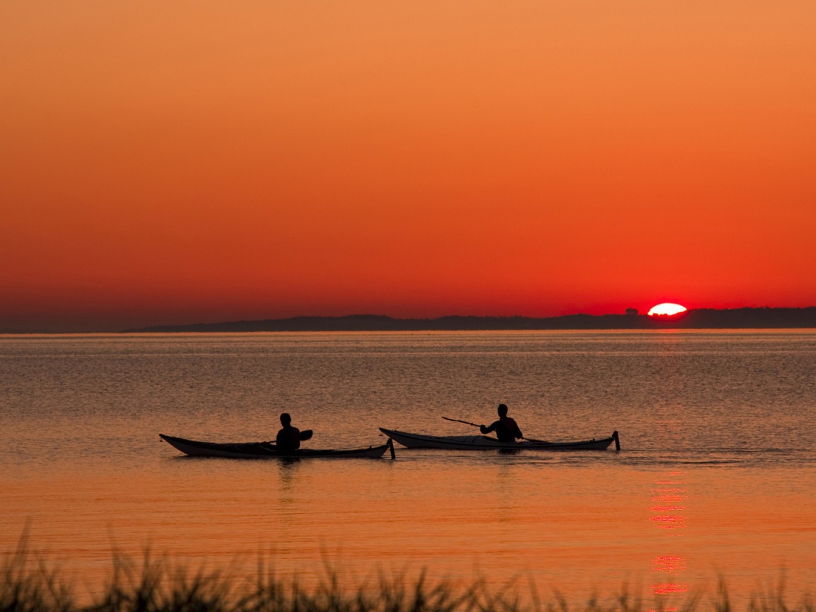 Два лодочника на фоне заката