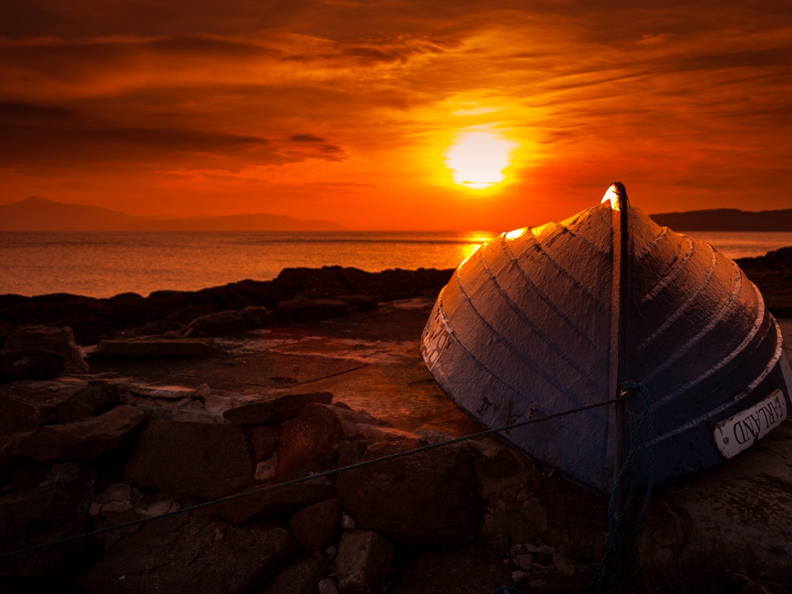 Перевернутая лодка на фоне заката