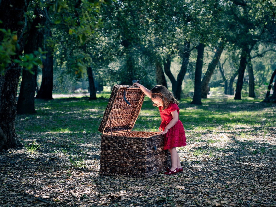 Девочка заглядывает в плетеную корзину