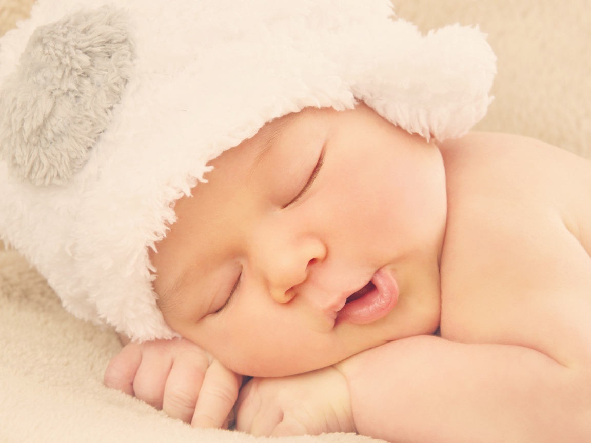 Спящий ребенок в белой шапке
