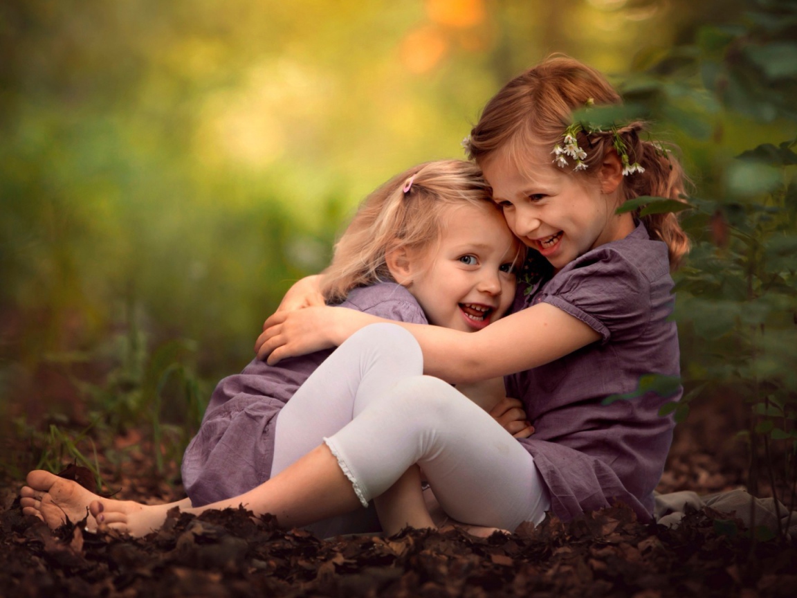 Две милых сестрички играют в парке