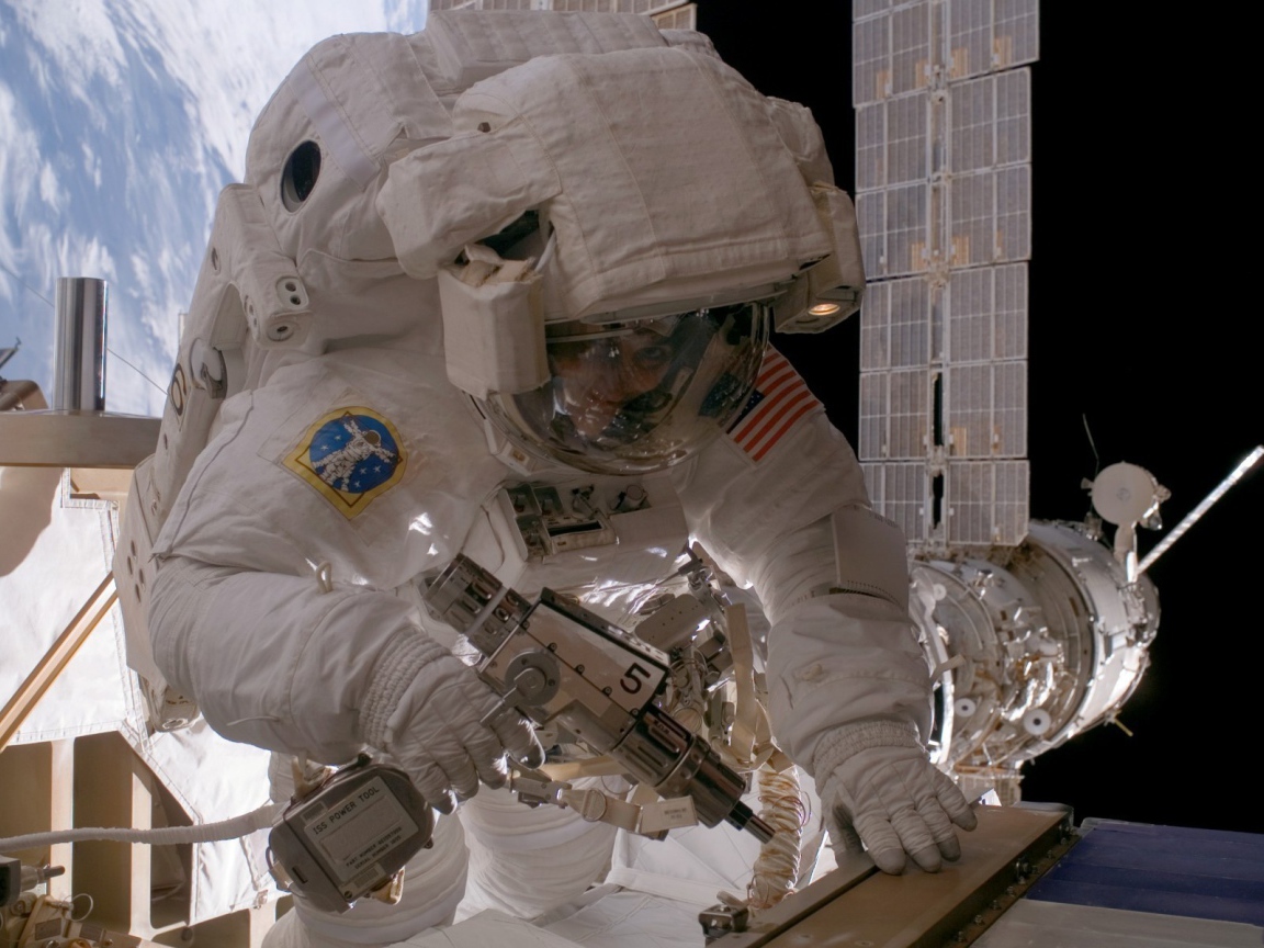 Космонавт на орбите выполняет ремонт