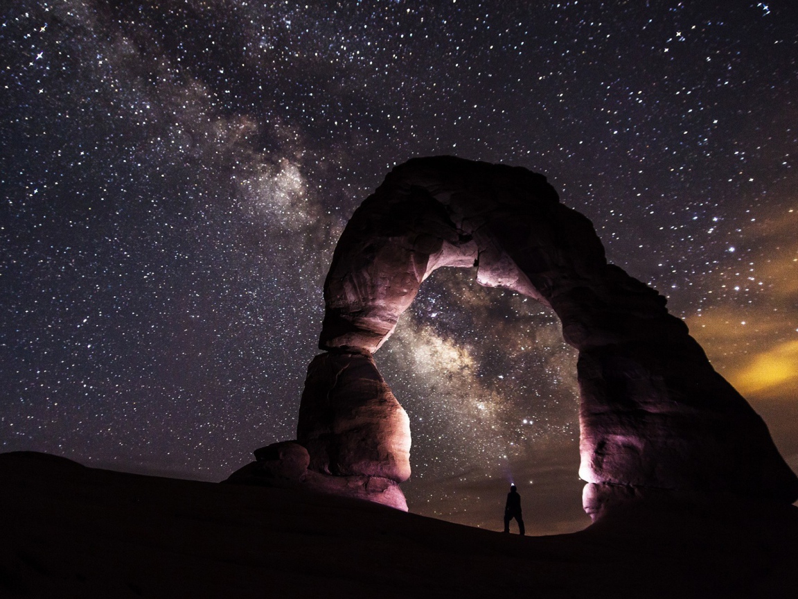 Природная каменная арка на фоне звезд