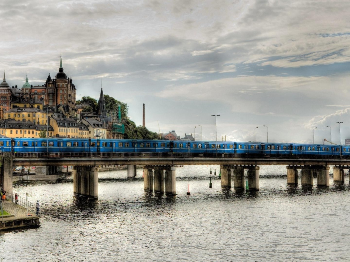 Поезд пересекает мост над рекой в Швеции