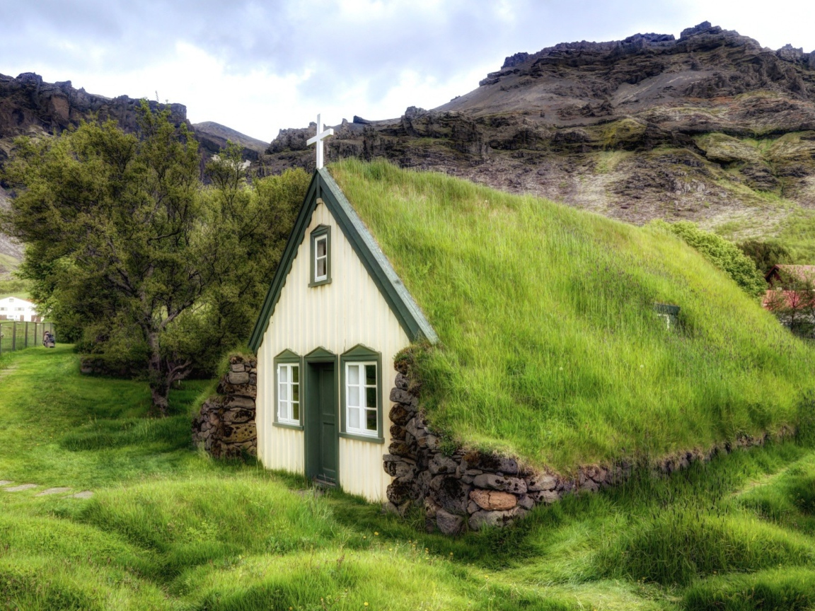 Поросшая травой крыша церкви в горной деревушке