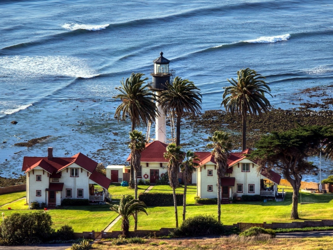 Маяк под пальмами на берегу моря