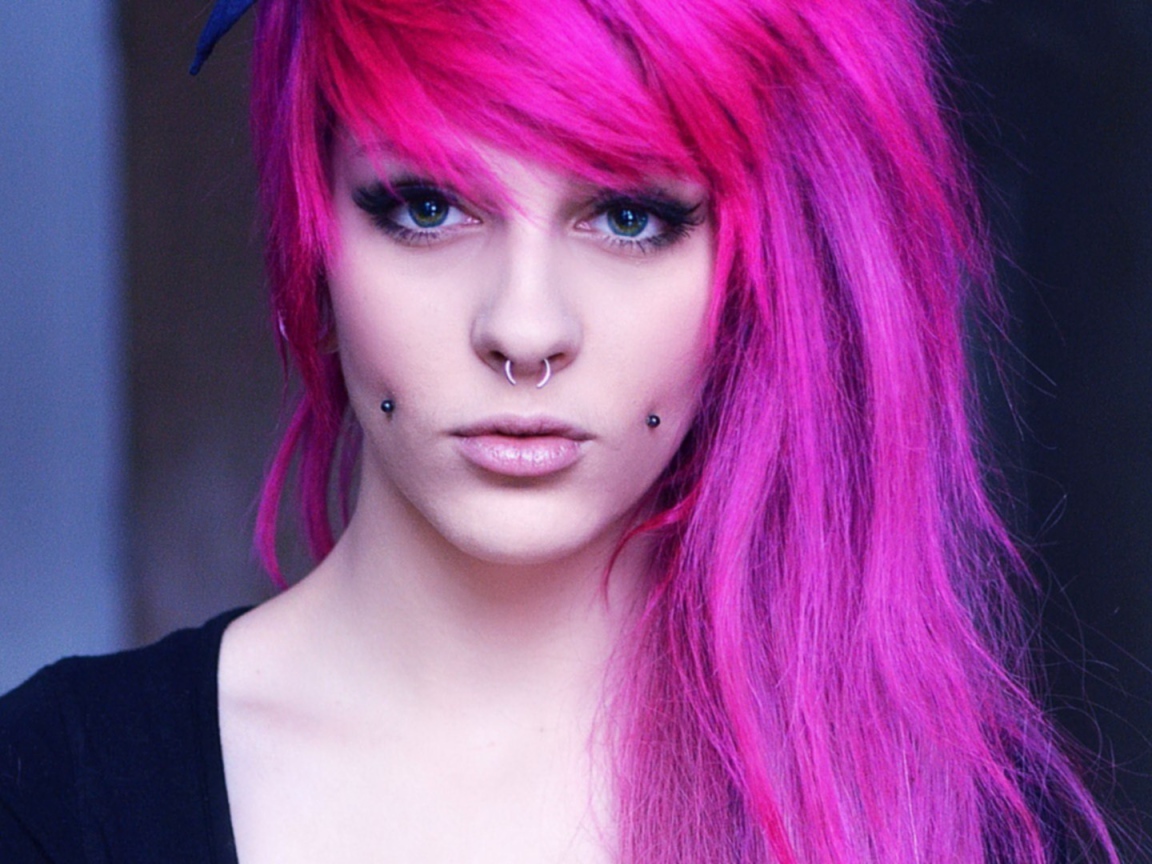 Девушка с розовыми волосами и пирсингом в щеках