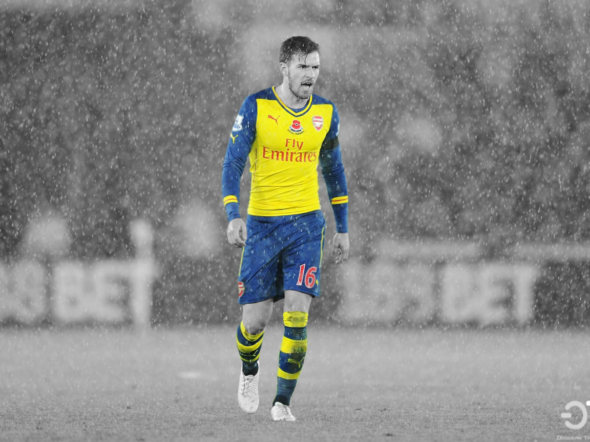 Arsenal player during rain, football