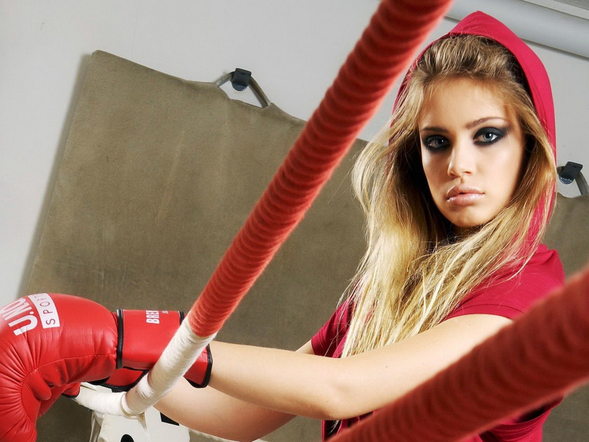 Блондинка в перчатках на боксерском ринге
