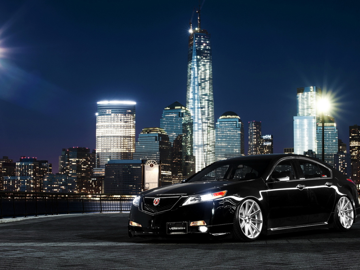 Черный автомобиль Acura TL на фоне ночных небоскребов 