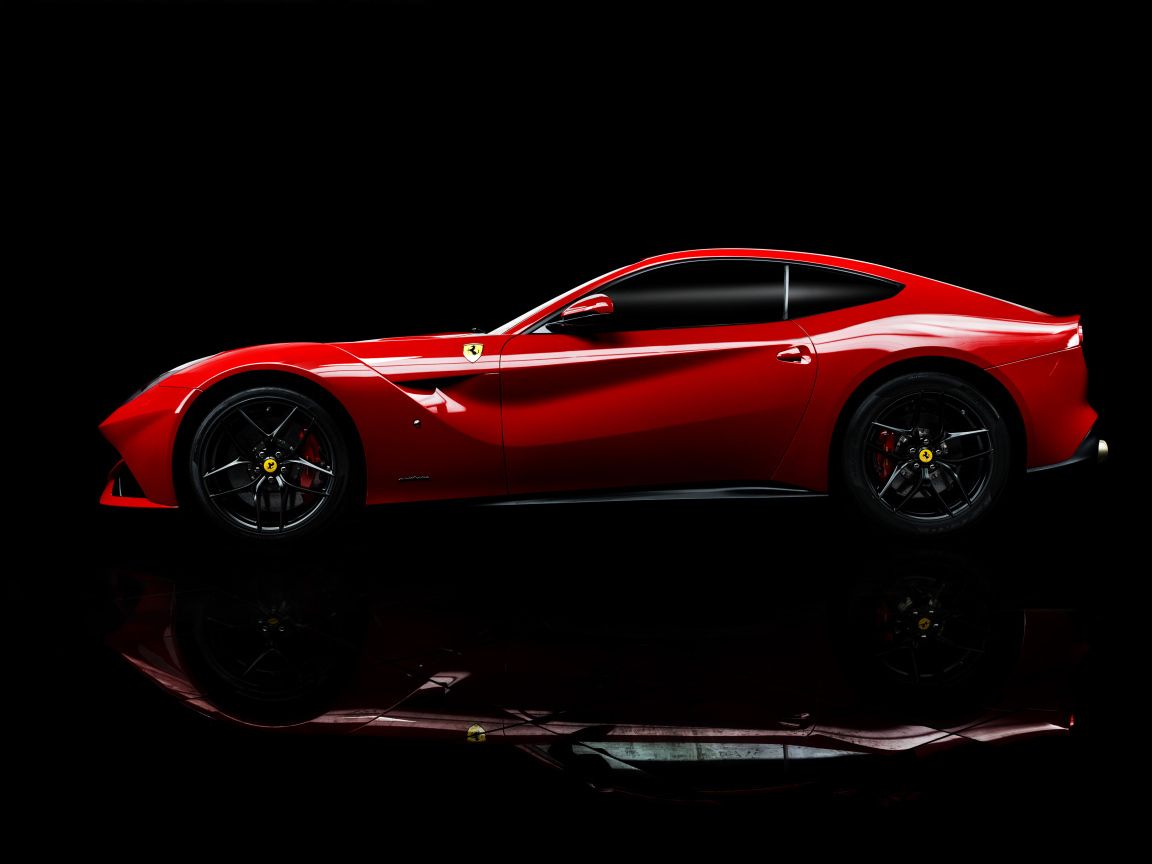 Красный спортивный автомобиль Ferrari F12 berlinetta на черном фоне