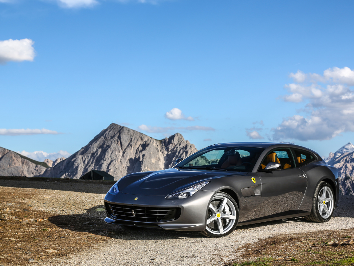 Серебристый автомобиль Ferrari GTC4Lusso на фоне голубого неба 