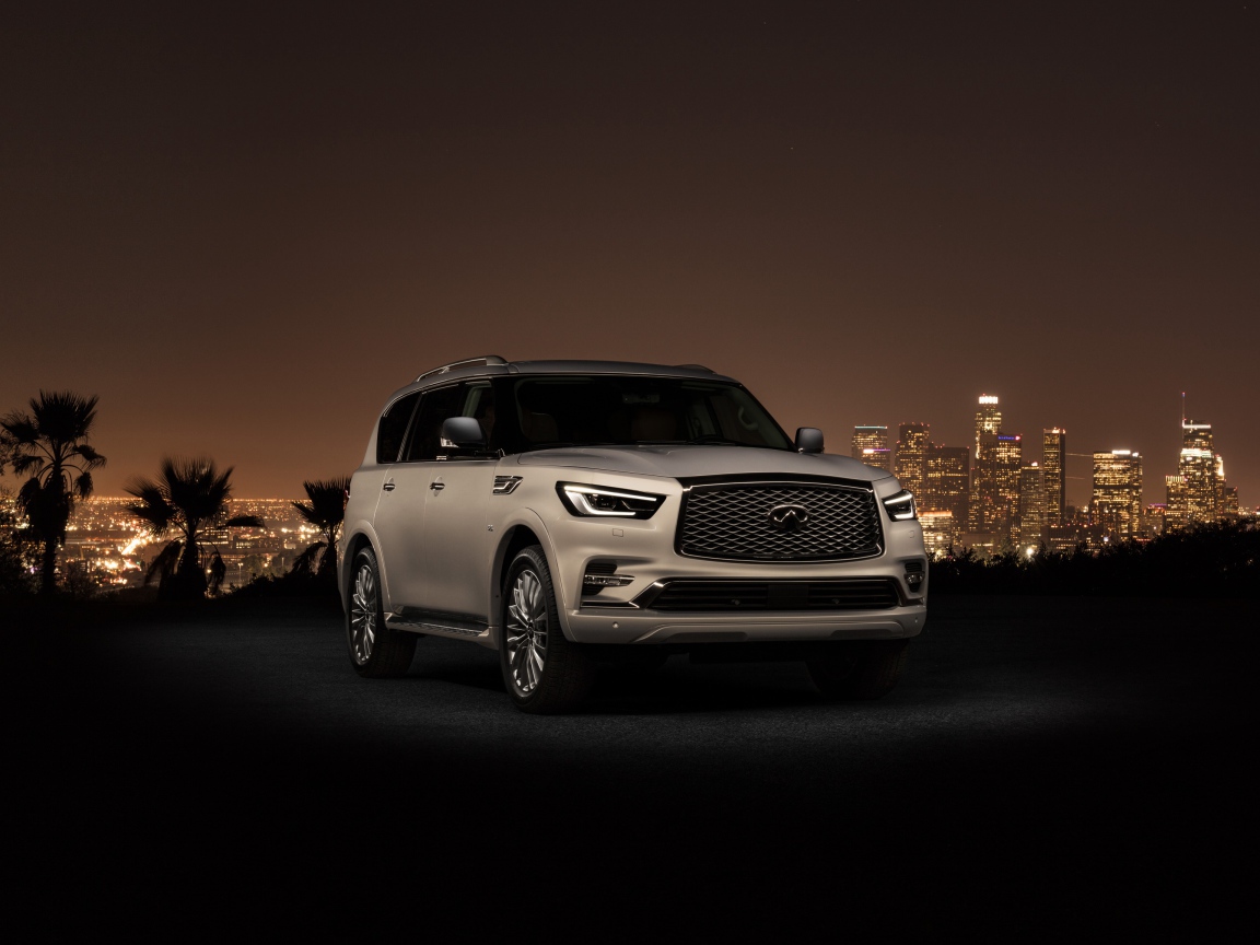 Автомобиль Infiniti QX80 2018 на фоне ночного города