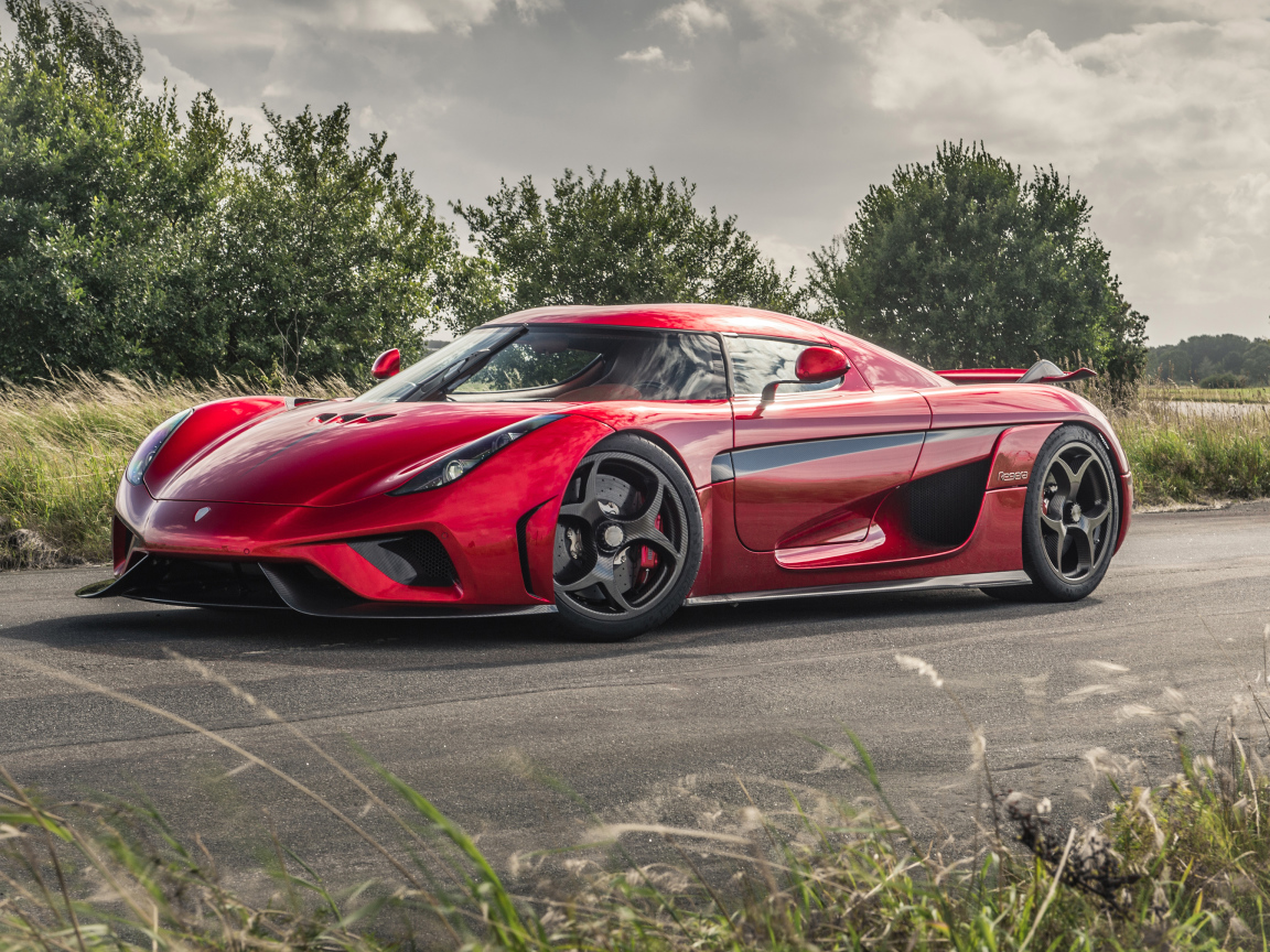 Красный спортивный автомобиль Koenigsegg Regera на дороге
