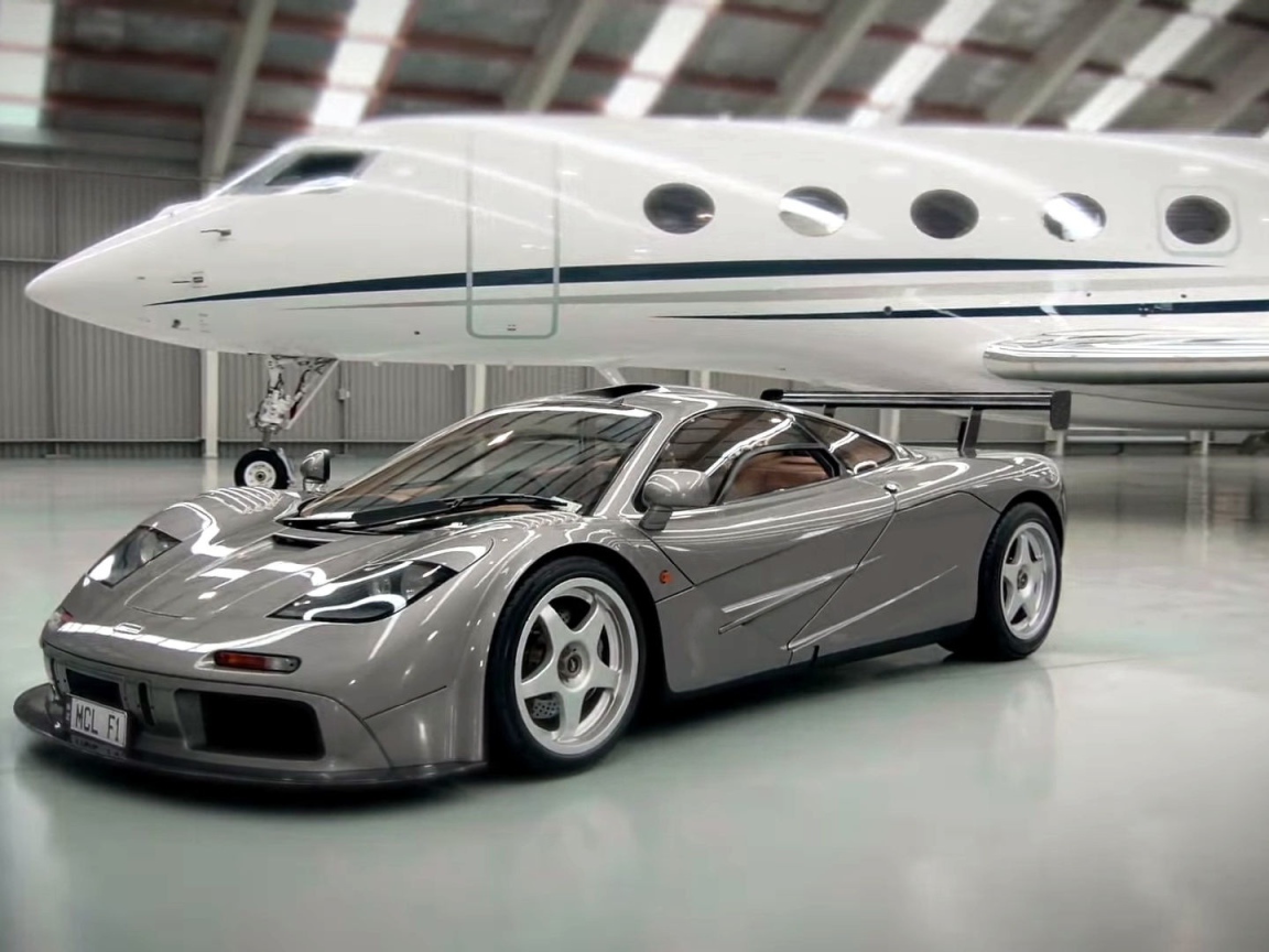 Спортивный автомобиль McLaren F1 на фоне самолета