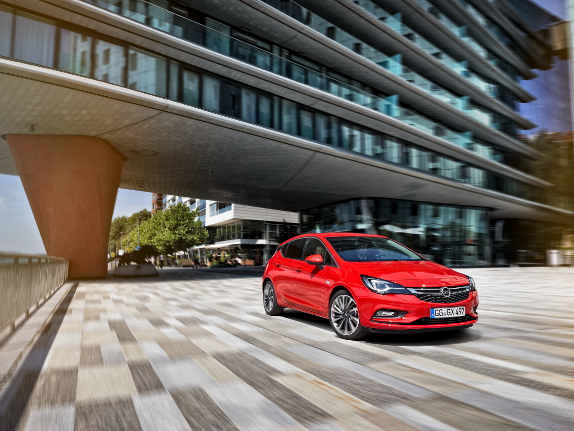 Красный автомобиль Opel Astra в движении