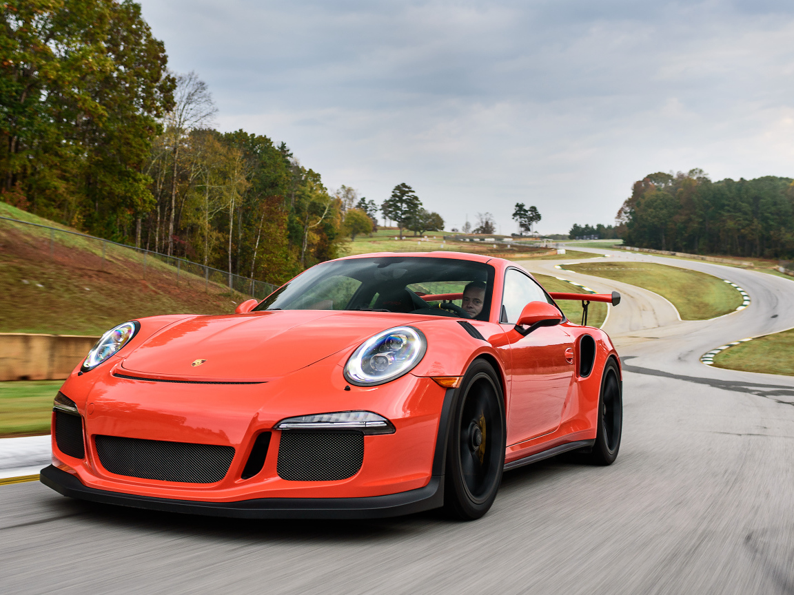 Оранжевый спортивный автомобиль Porsche 911 GT3 на трассе