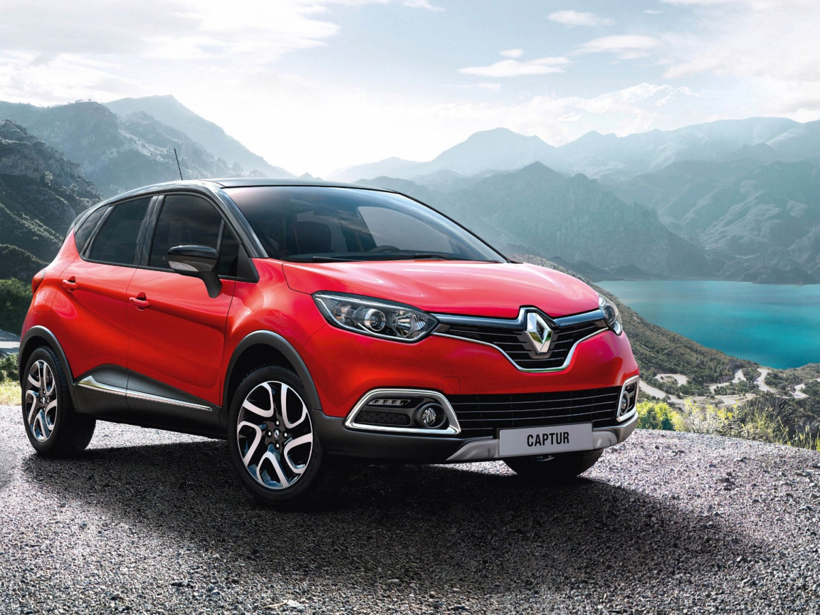 Красный автомобиль внедорожник Renault Captur на фоне гор