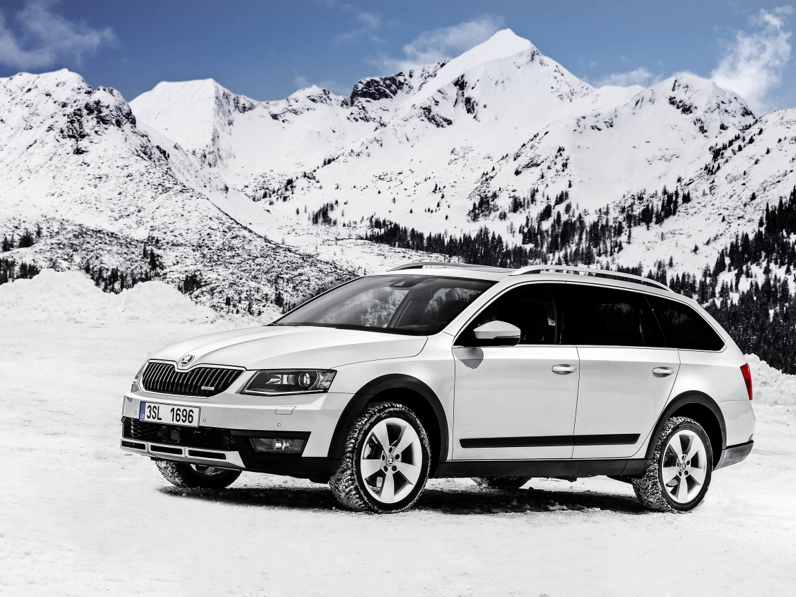 Белый автомобиль Skoda Octavia на фоне заснеженных гор